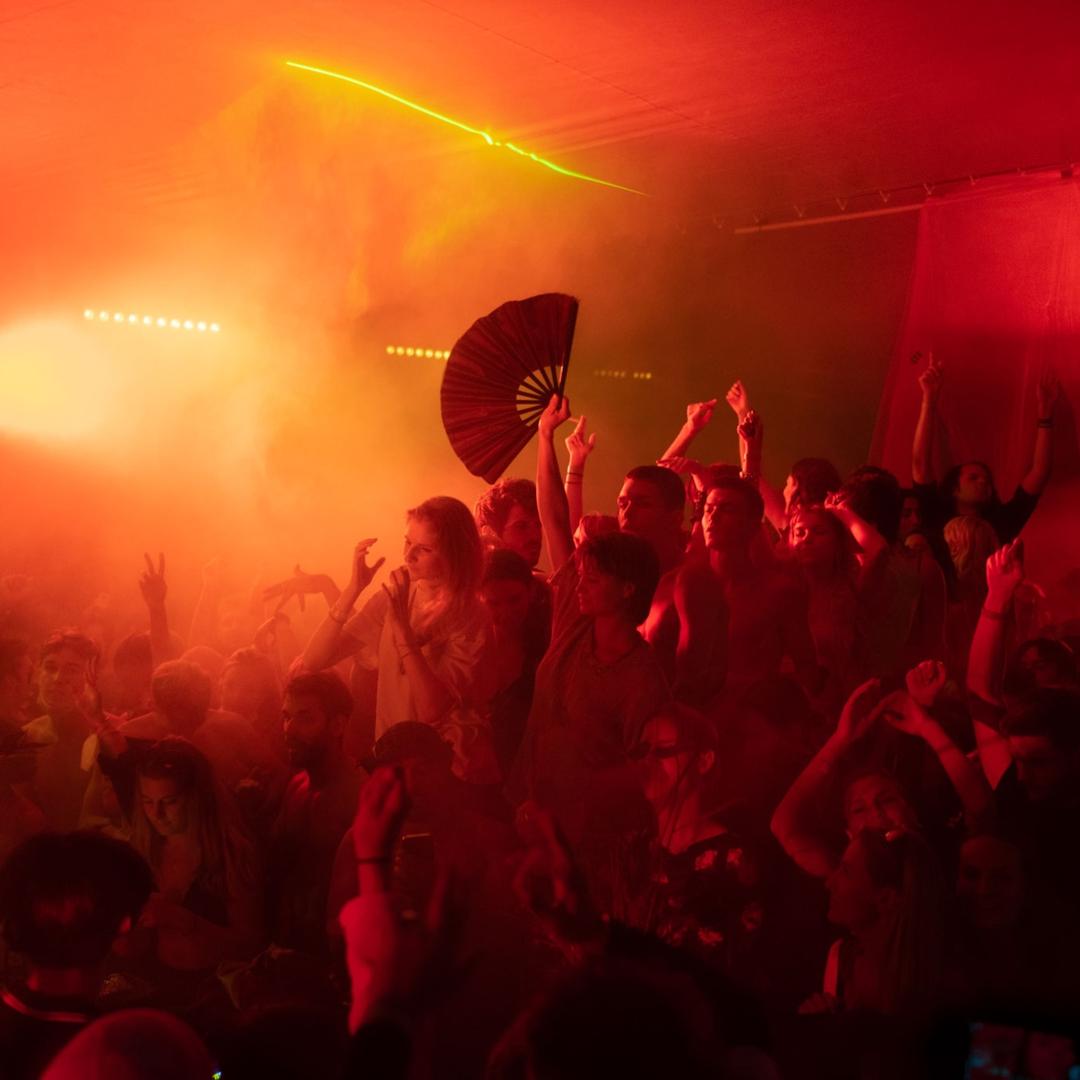 Crowd under neon lights at Berlin techno event